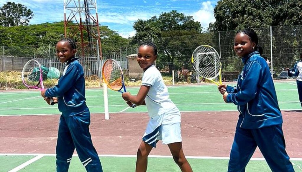 Learners with tennis rackets on the school court